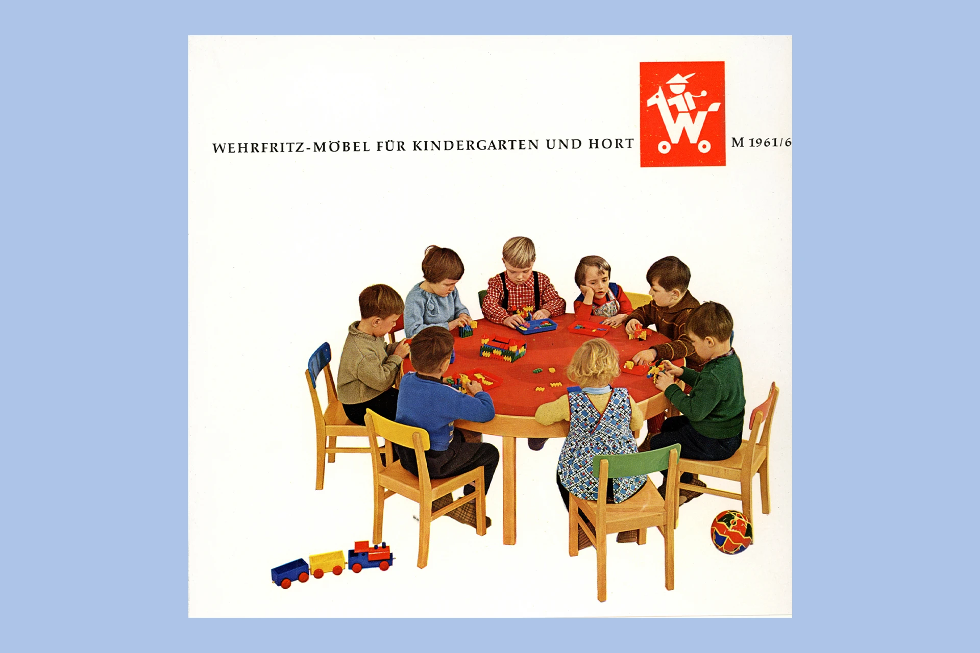 Katalog-Titelseite der Firma Wehrfritz mit einem Foto von Kindern, die an einem Tisch sitzen.