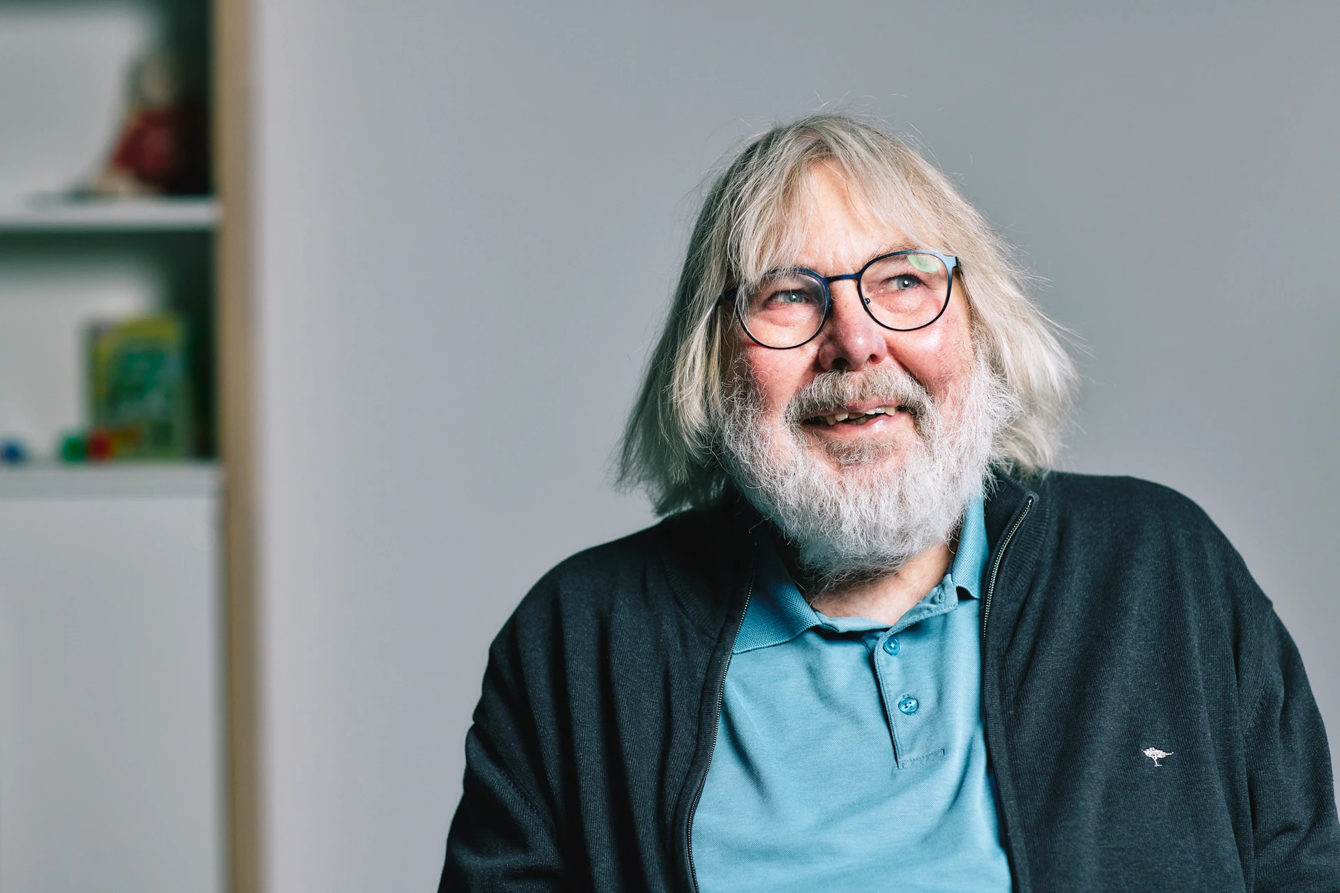 Portraitfoto von Horst Dwinger. Er hat weißes Haar und Bart, trägt eine Brille und ein blaues Poloshirt.