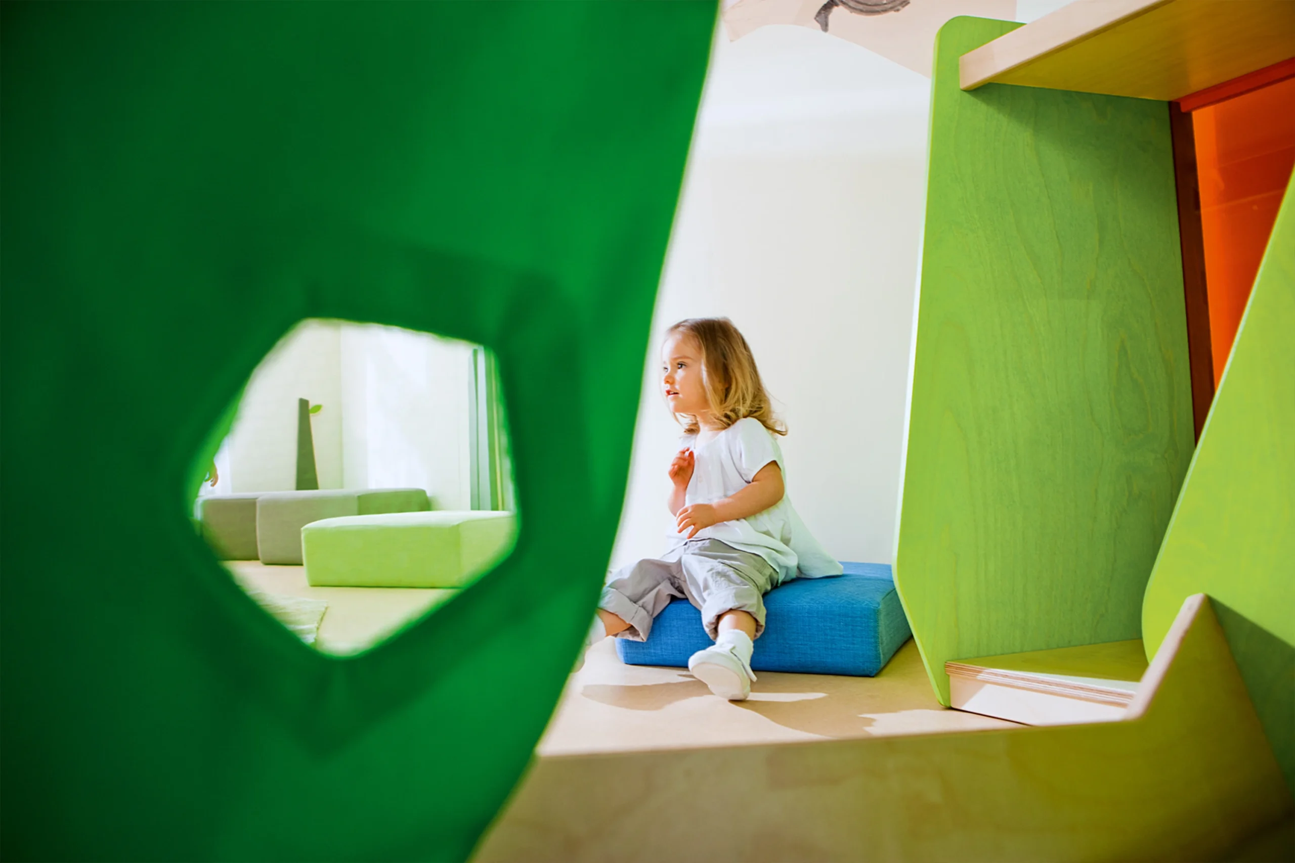 Ein Kind sitzt in einem Raumsystem der Firma Wehrfritz.