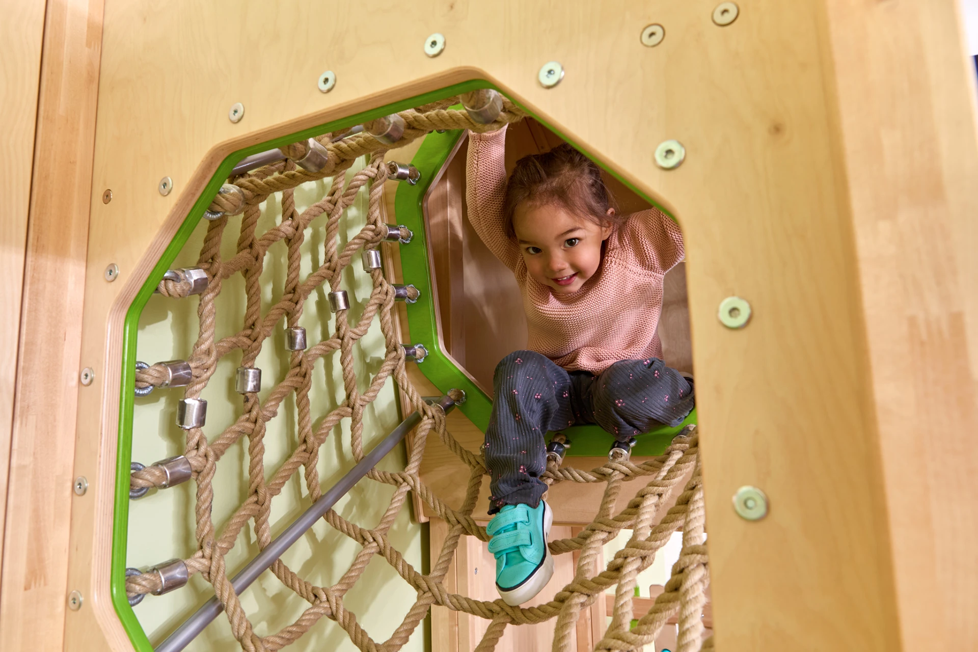 Ein Kind klettert durch einen Spieltunnel.