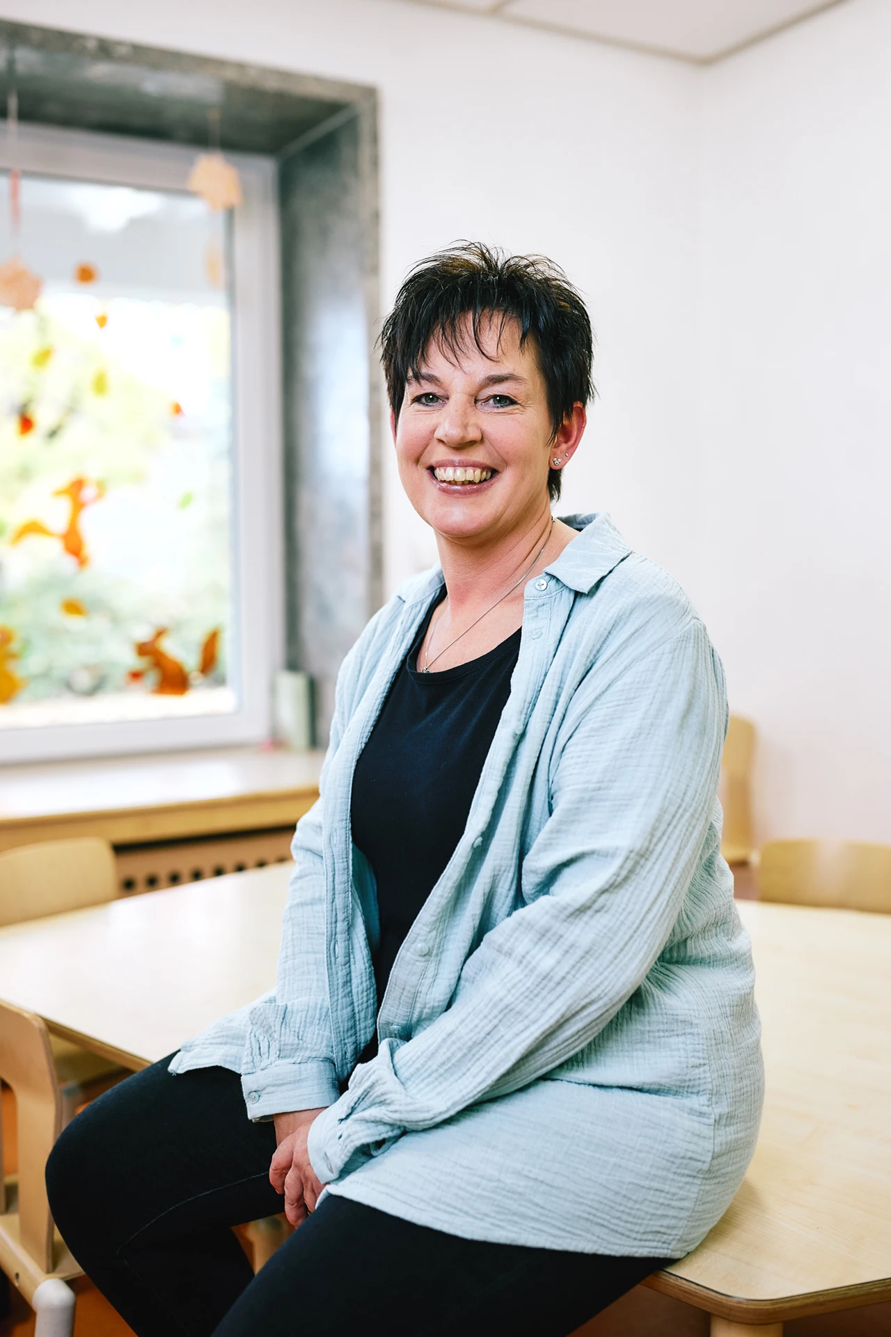 Portraitfoto von Bianca Kupfer. Sie hat schwarze Haare und trägt eine blaue Bluse.