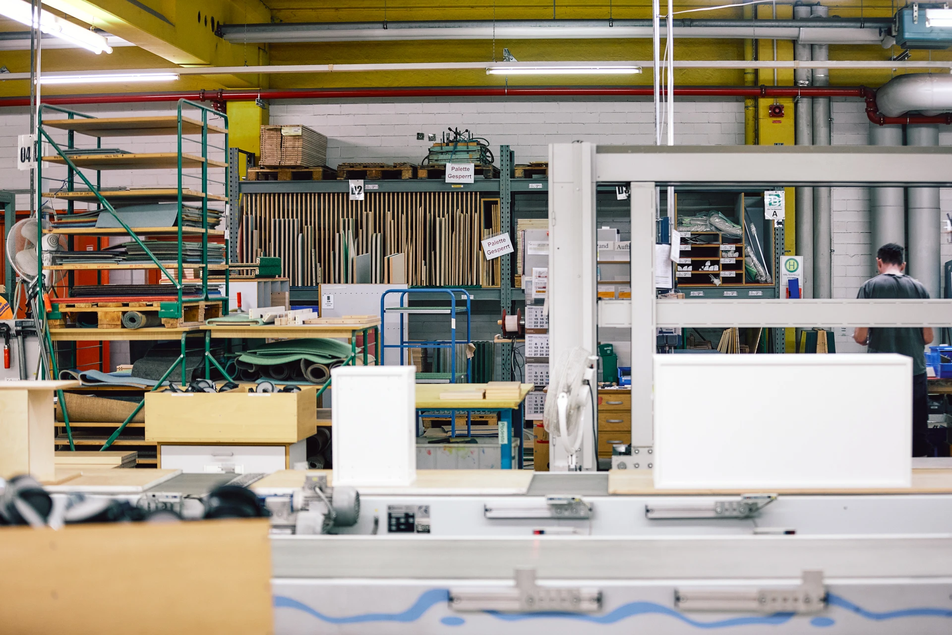 Eine Produktionshalle mit diversen Geräten und Regalen.