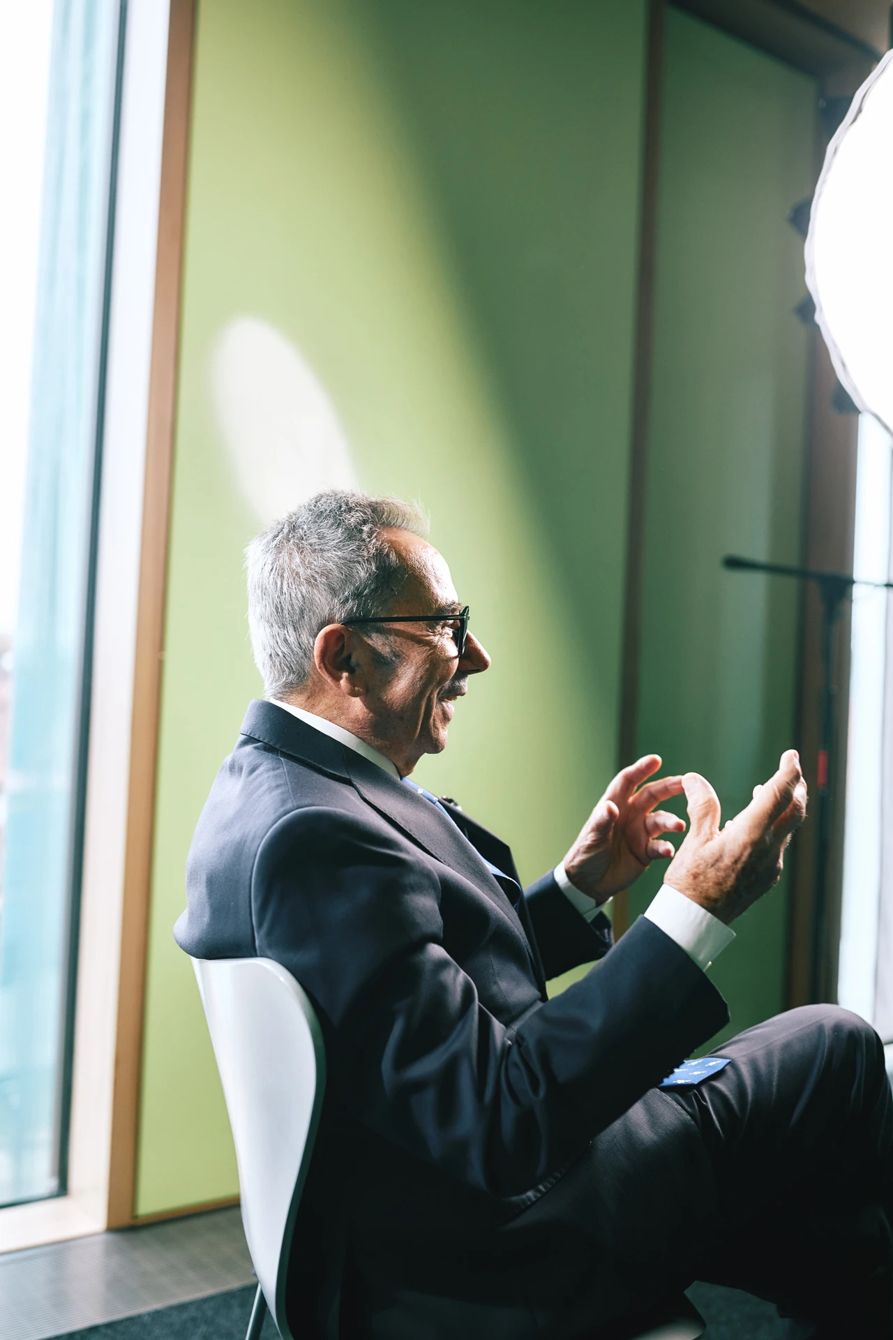 Prof. Dr. mult. Wassilios E. Fthenakis sitzt auf einem Stuhl und gestikuliert.