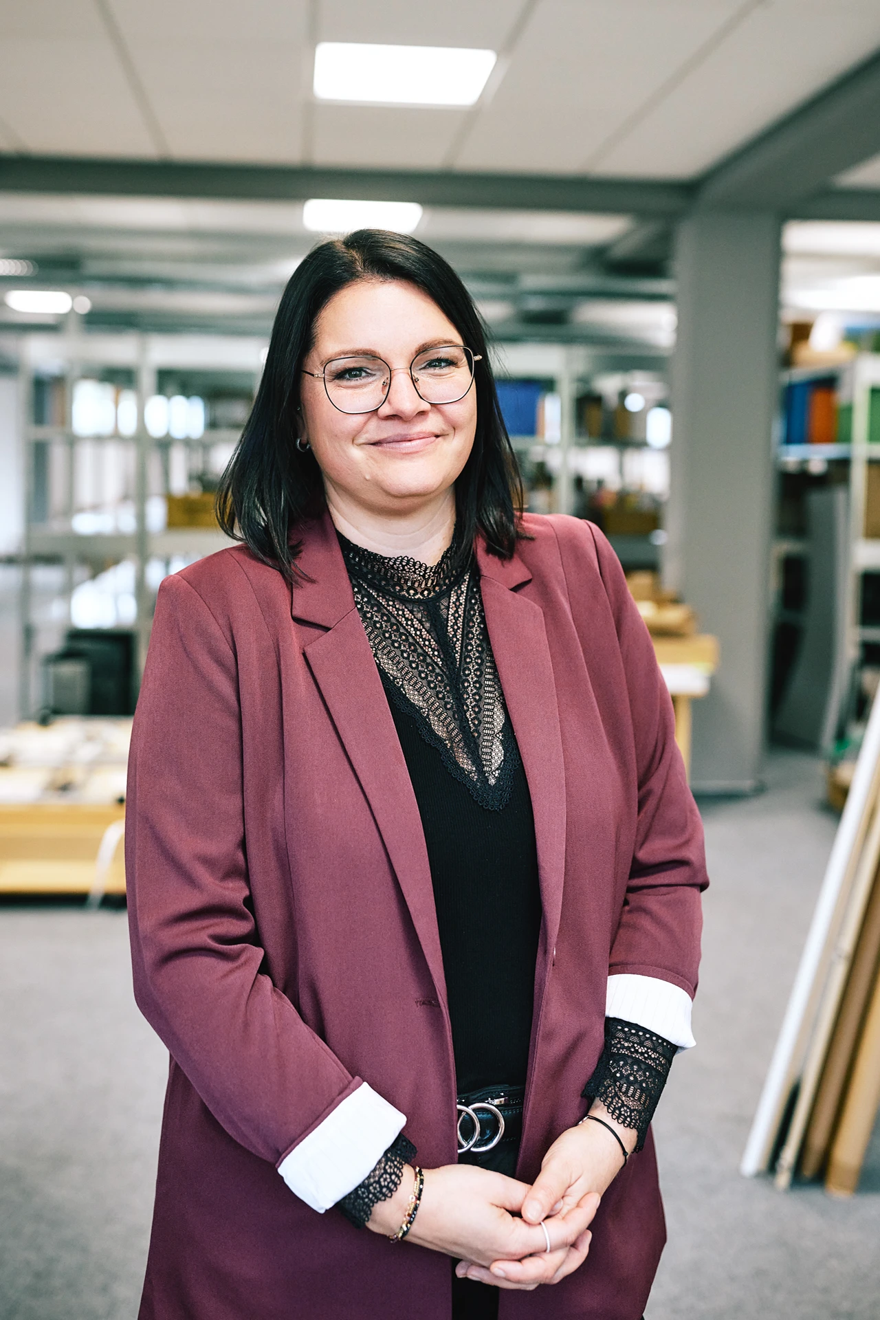 Portraitfoto von Janina Kopp. Sie hat braune Haare, trägt eine Brille und einen roten Blazer.